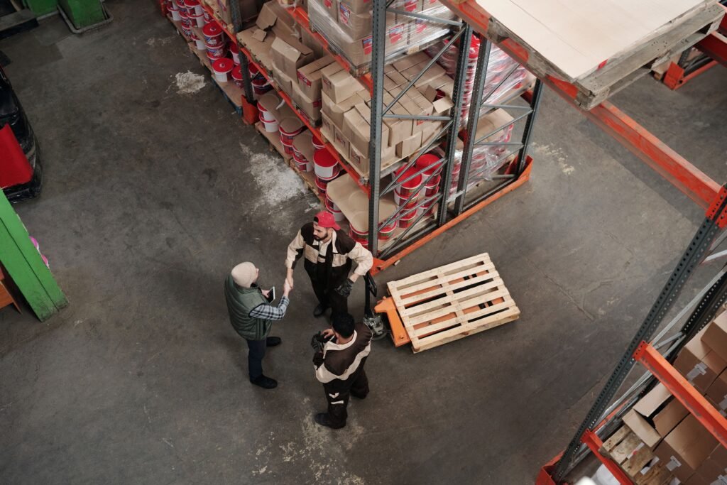 High angle view of workers discussing logistics in a warehouse setting.
